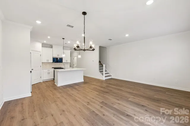 a large kitchen with kitchen island a island a sink stainless steel appliances and cabinets