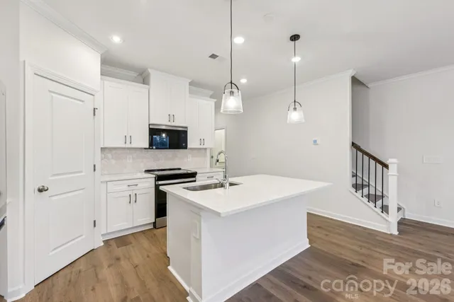 a kitchen with white cabinets and stainless steel appliances