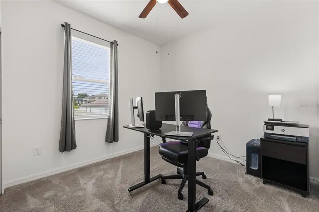 a view of a workspace with furniture and a window