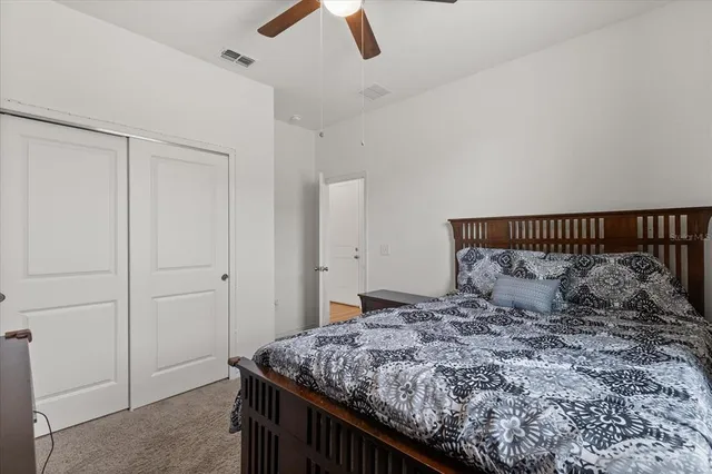 a bedroom with a bed and a ceiling fan