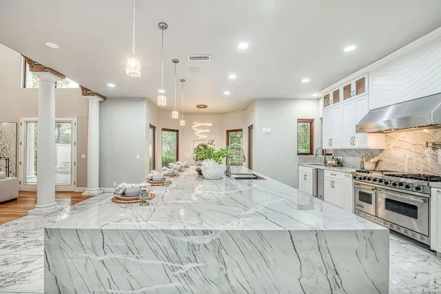 a kitchen with stainless steel appliances kitchen island granite countertop a sink and cabinets
