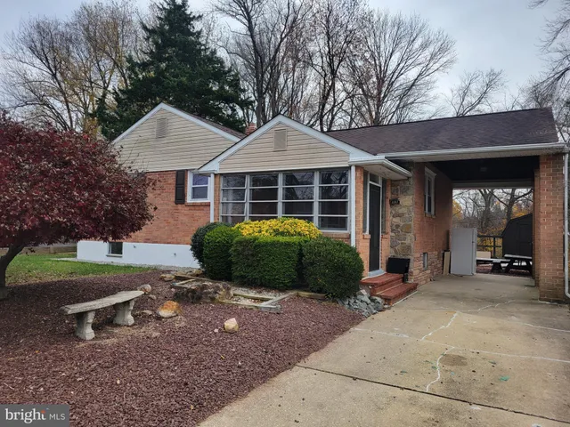 a view of a house with a yard and large tree