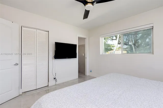 a bedroom with a bed and a flat screen tv
