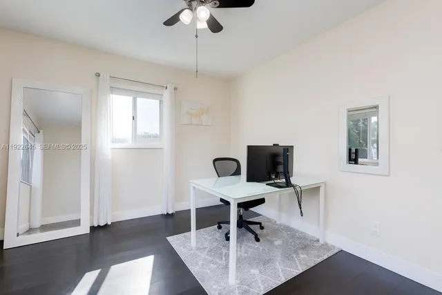 a view of a workspace with furniture and a window