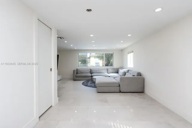 a living room with fireplace furniture and white walls