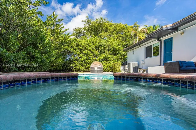 a view of a swimming pool with a table and chairs in patio