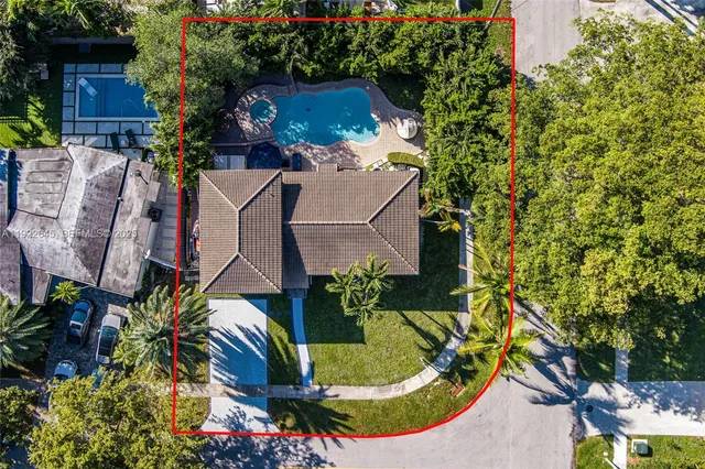 an aerial view of a house with a yard and large trees