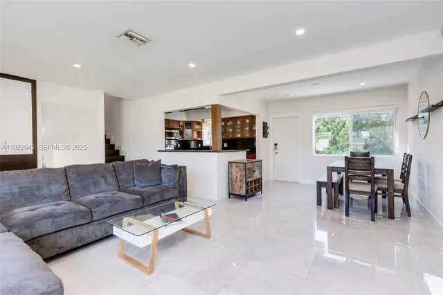 a living room with furniture and a dining area with kitchen view