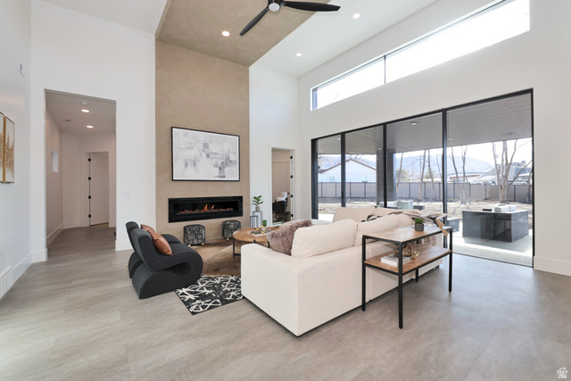 1306 East Victor Lane Draper, UT 84020 - Photo 11 of 60 Living area featuring a fireplace, recessed lighting, a ceiling fan, and a high ceiling