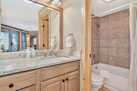 a bathroom with a granite countertop sink a toilet and bathtub