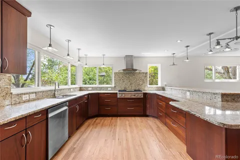 a large kitchen with stainless steel appliances granite countertop a sink stove and cabinets