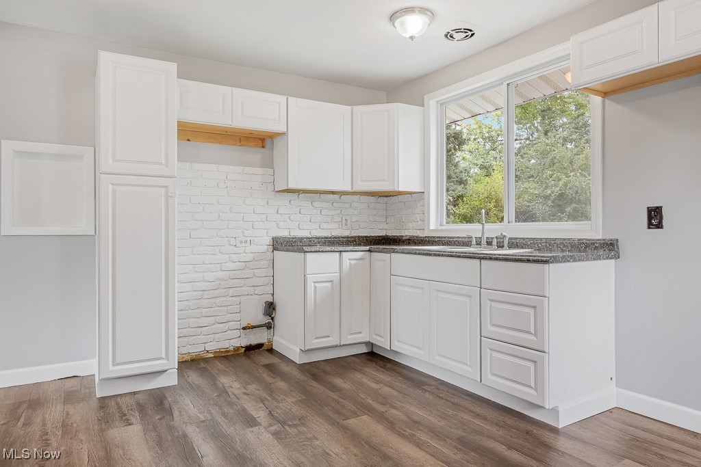 410 Longview Road Medina, OH 44256 - Photo 12 of 50 Kitchen featuring brick wall, white cabinets, sink, and dark hardwood / wood-style flooring