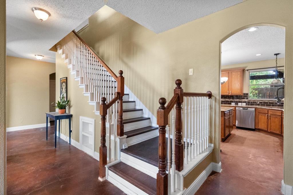 1305 Liverpool Lane Mansfield, TX 76063 - Photo 2 of 40 The interior features a staircase with white risers, dark wood treads, and white balusters