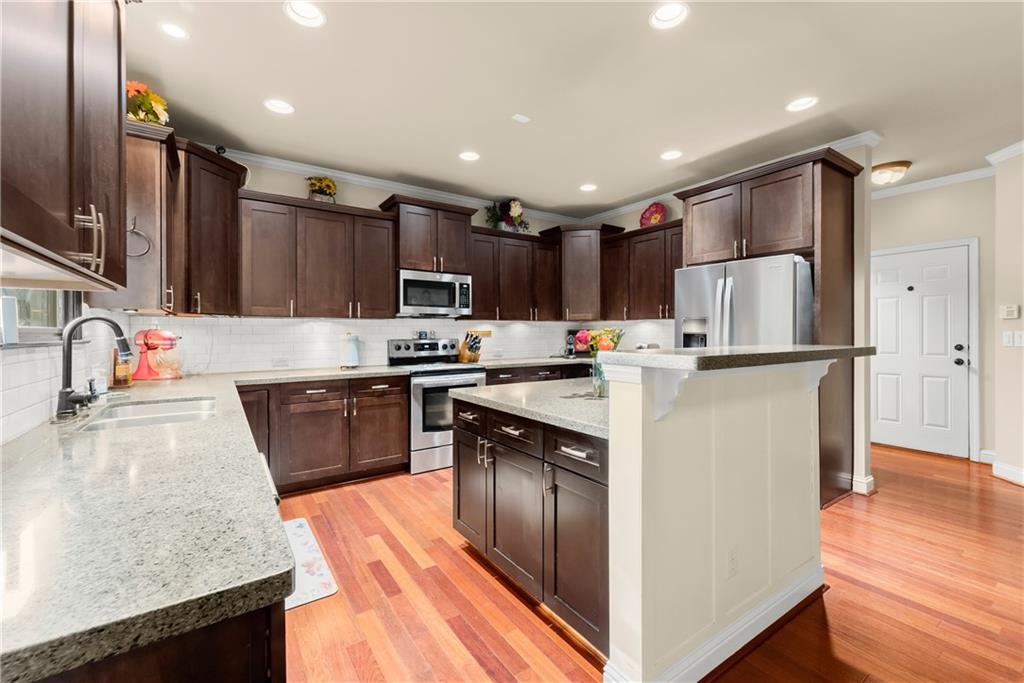 799 Traditions Way Jefferson, GA 30549 - Photo 10 of 53 a kitchen with kitchen island granite countertop stainless steel appliances cabinets a sink and a center island