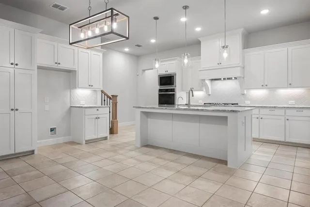a large white kitchen with a sink and cabinets