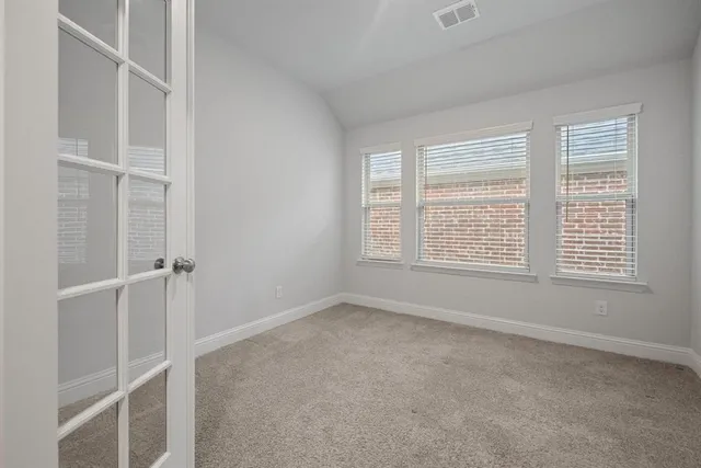 a view of an empty room with a chandelier fan