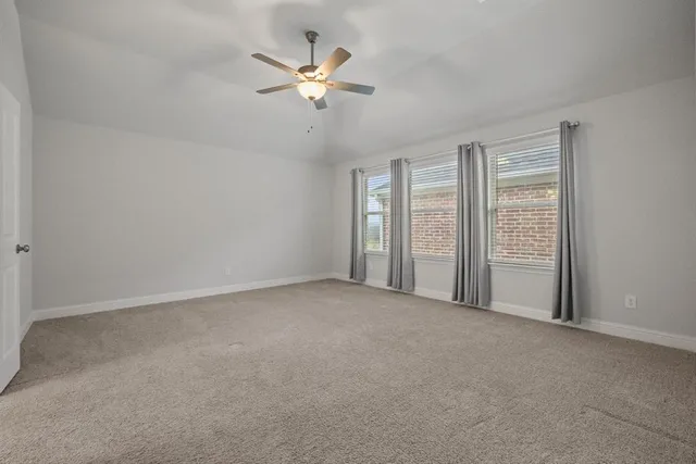 an empty room with a ceiling fan and a window