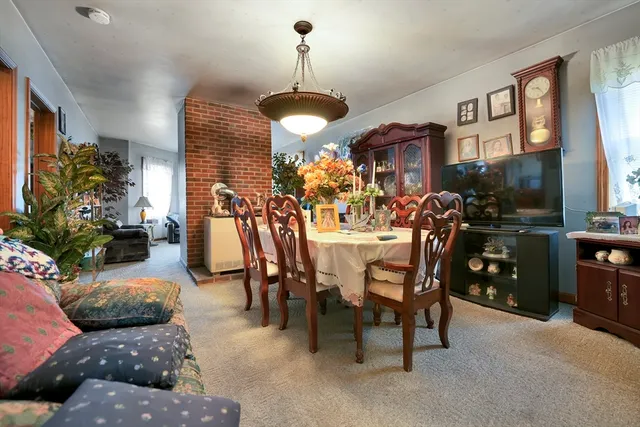 a view of a dining room and livingroom with furniture wooden floor a chandelier