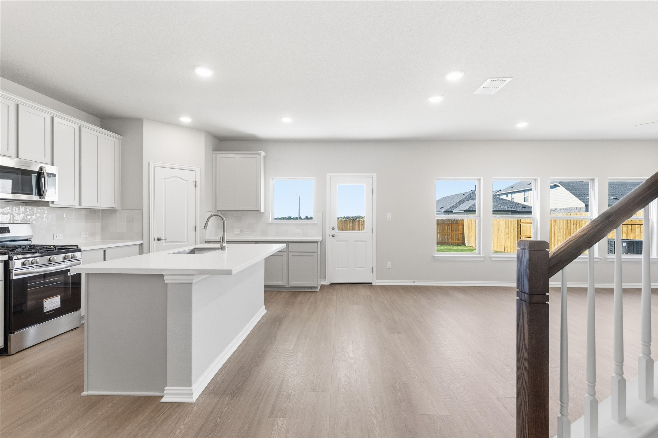 13700 Tucker Hedge Pass Elgin, TX 78621 - Photo 2 of 16 Kitchen with stainless steel appliances, decorative backsplash, healthy amount of natural light, recessed lighting, and light wood finished floors