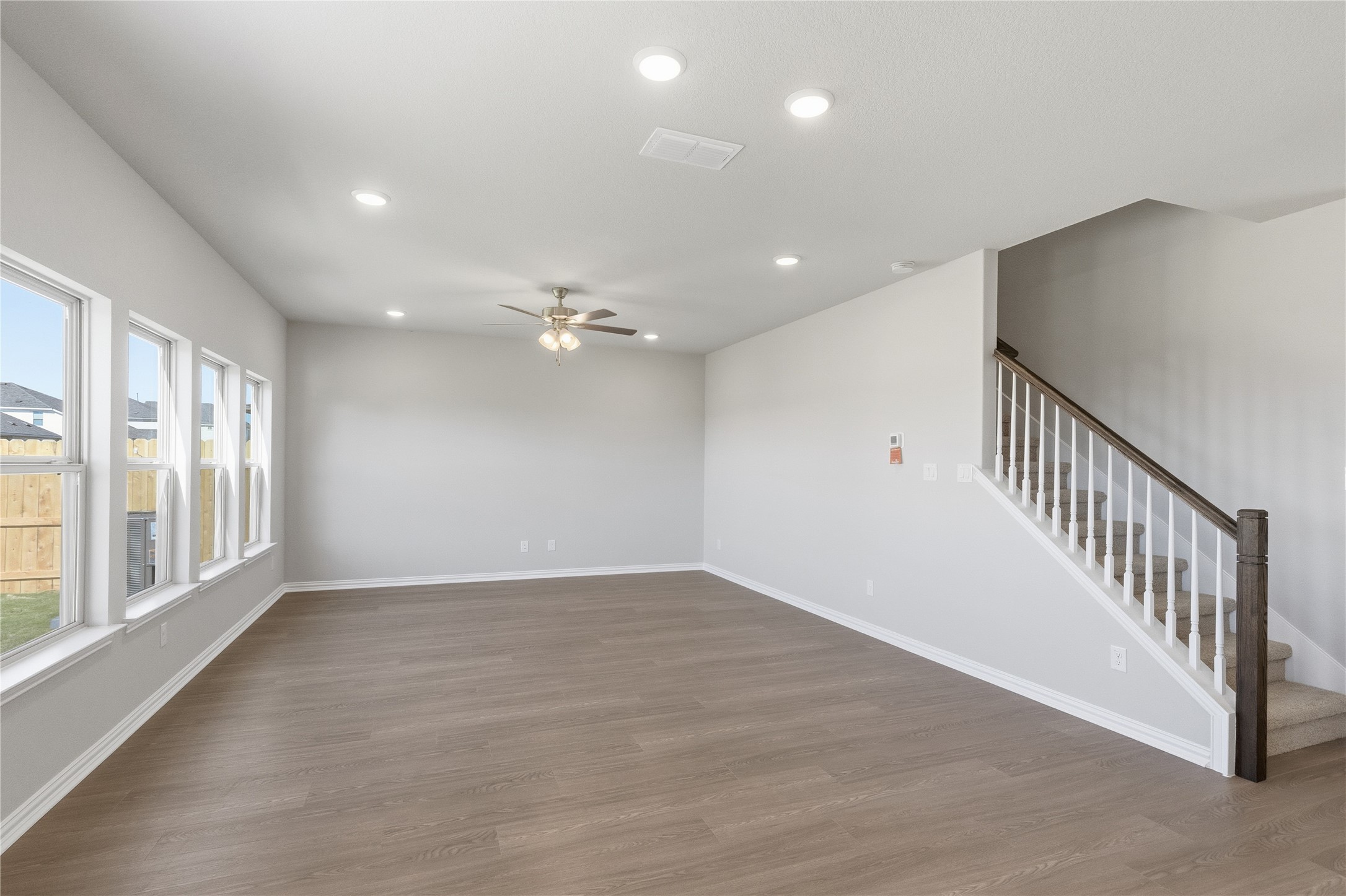 13700 Tucker Hedge Pass Elgin, TX 78621 - Photo 4 of 16 Unfurnished living room featuring recessed lighting, wood finished floors, stairway, and a ceiling fan