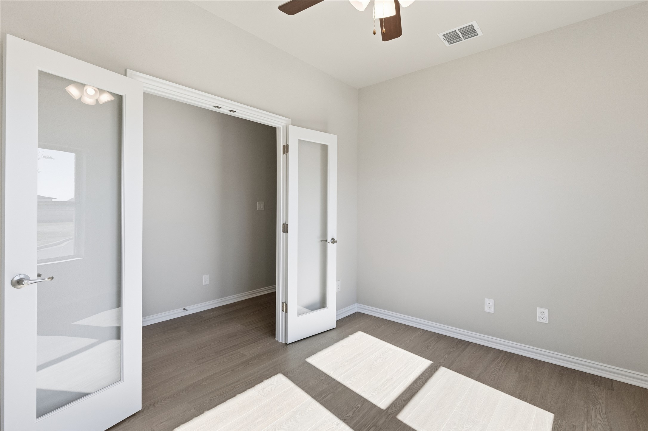 13700 Tucker Hedge Pass Elgin, TX 78621 - Photo 5 of 16 Unfurnished bedroom featuring french doors, wood finished floors, and ceiling fan