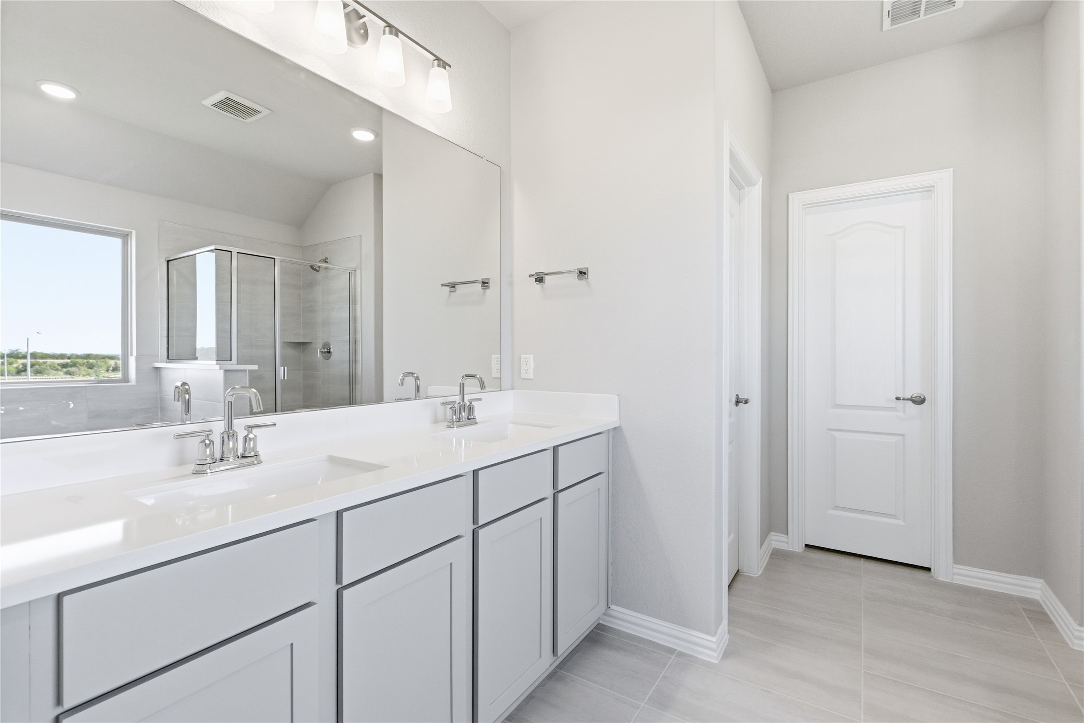13700 Tucker Hedge Pass Elgin, TX 78621 - Photo 7 of 16 Full bath featuring a shower stall, double vanity, light tile patterned flooring, recessed lighting, and vaulted ceiling