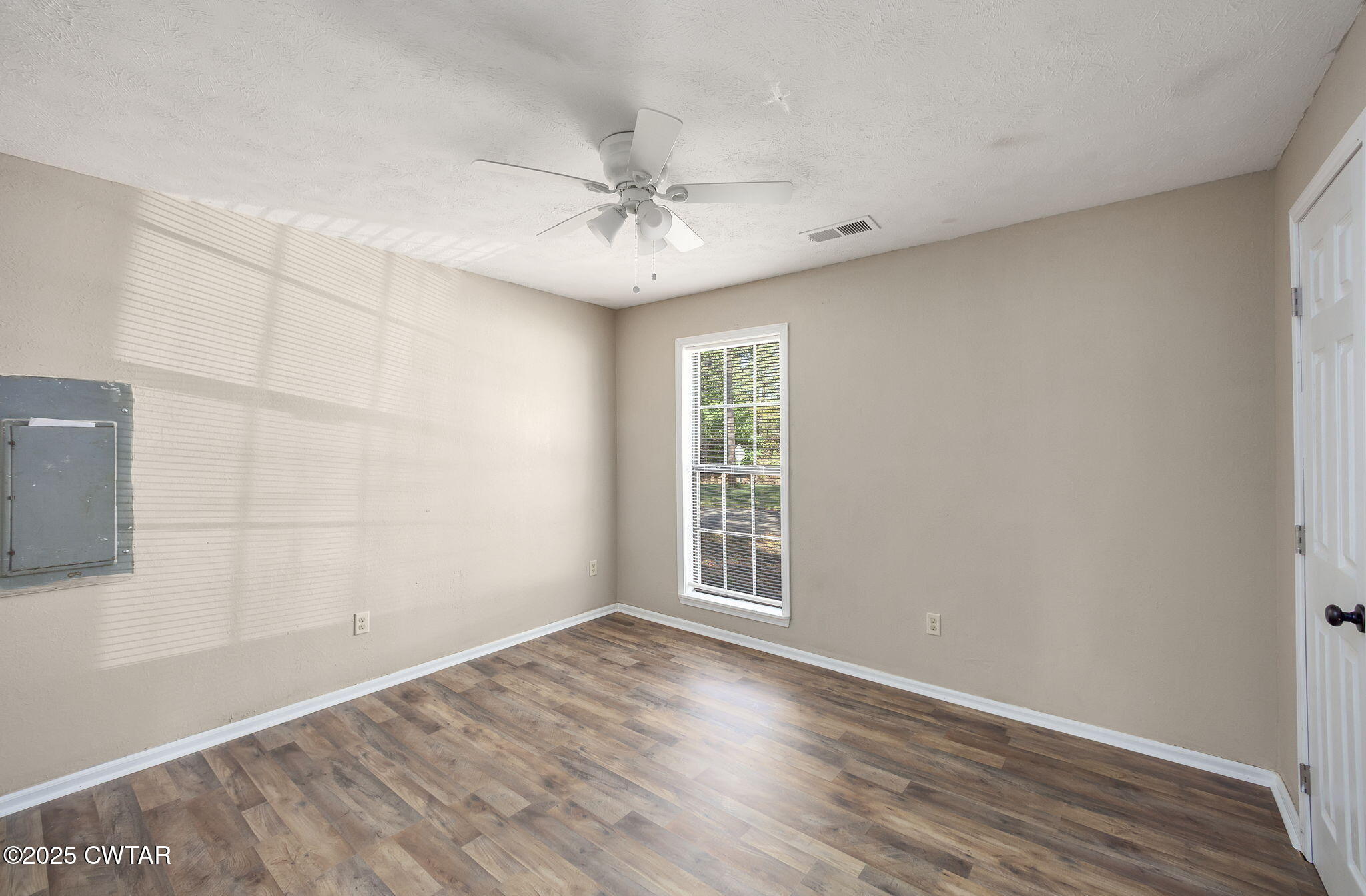 4135 Eurekaton Road Stanton, TN 38069 - Photo 10 of 33 an empty room with wooden floor fan and windows