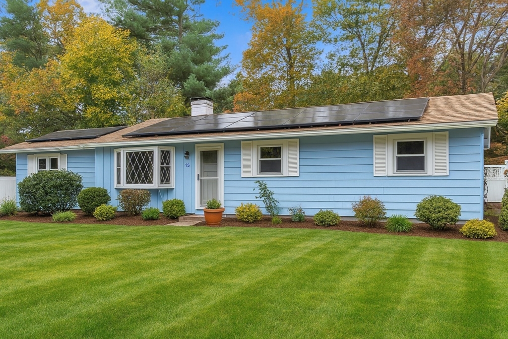 a front view of a house with a yard and trees