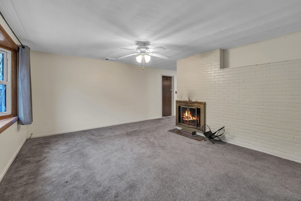 15 Fairbrook Road Framingham, MA 01701 - Photo 3 of 28 a view of a livingroom with a fireplace and a ceiling fan