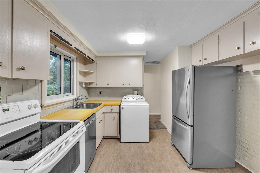 15 Fairbrook Road Framingham, MA 01701 - Photo 8 of 28 a kitchen with a refrigerator a sink and cabinets