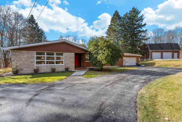a view of pool with large trees and wooden fence