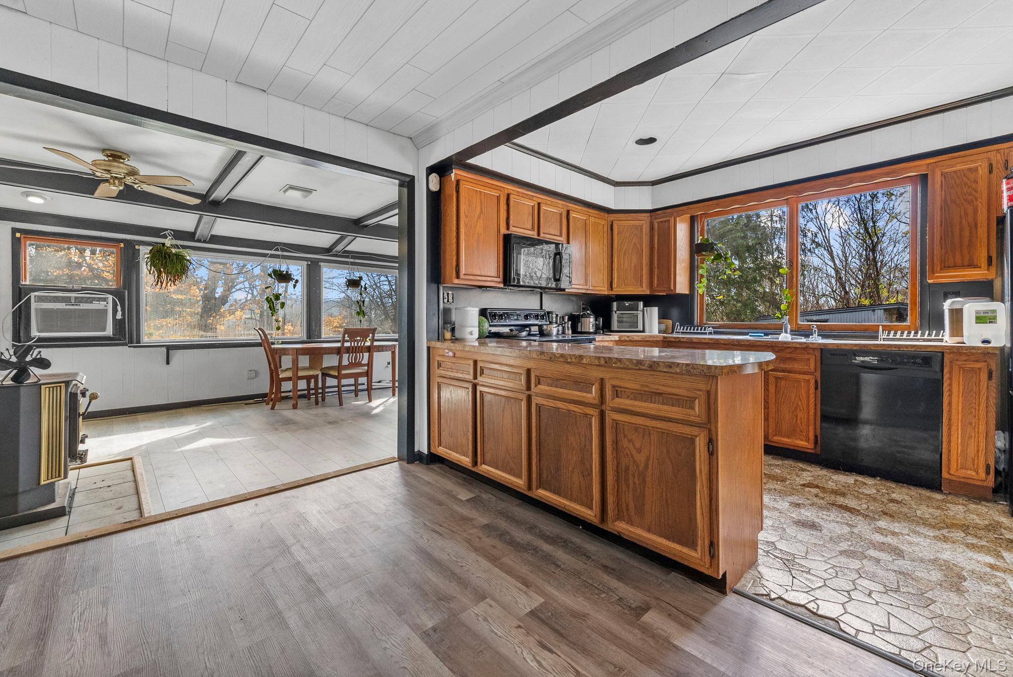 45 Baker Road Hopewell Junction, NY 12533 - Photo 11 of 41 a kitchen with stainless steel appliances granite countertop a stove a sink dishwasher and wooden cabinets with a large window