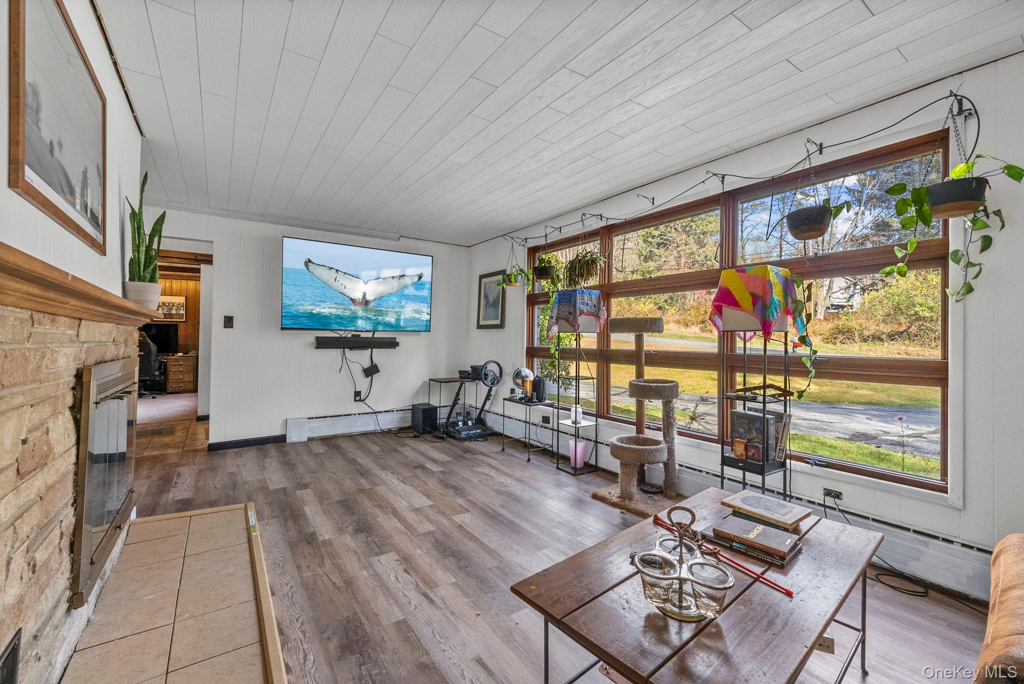 45 Baker Road Hopewell Junction, NY 12533 - Photo 19 of 41 a living room with furniture a flat screen tv and a floor to ceiling window