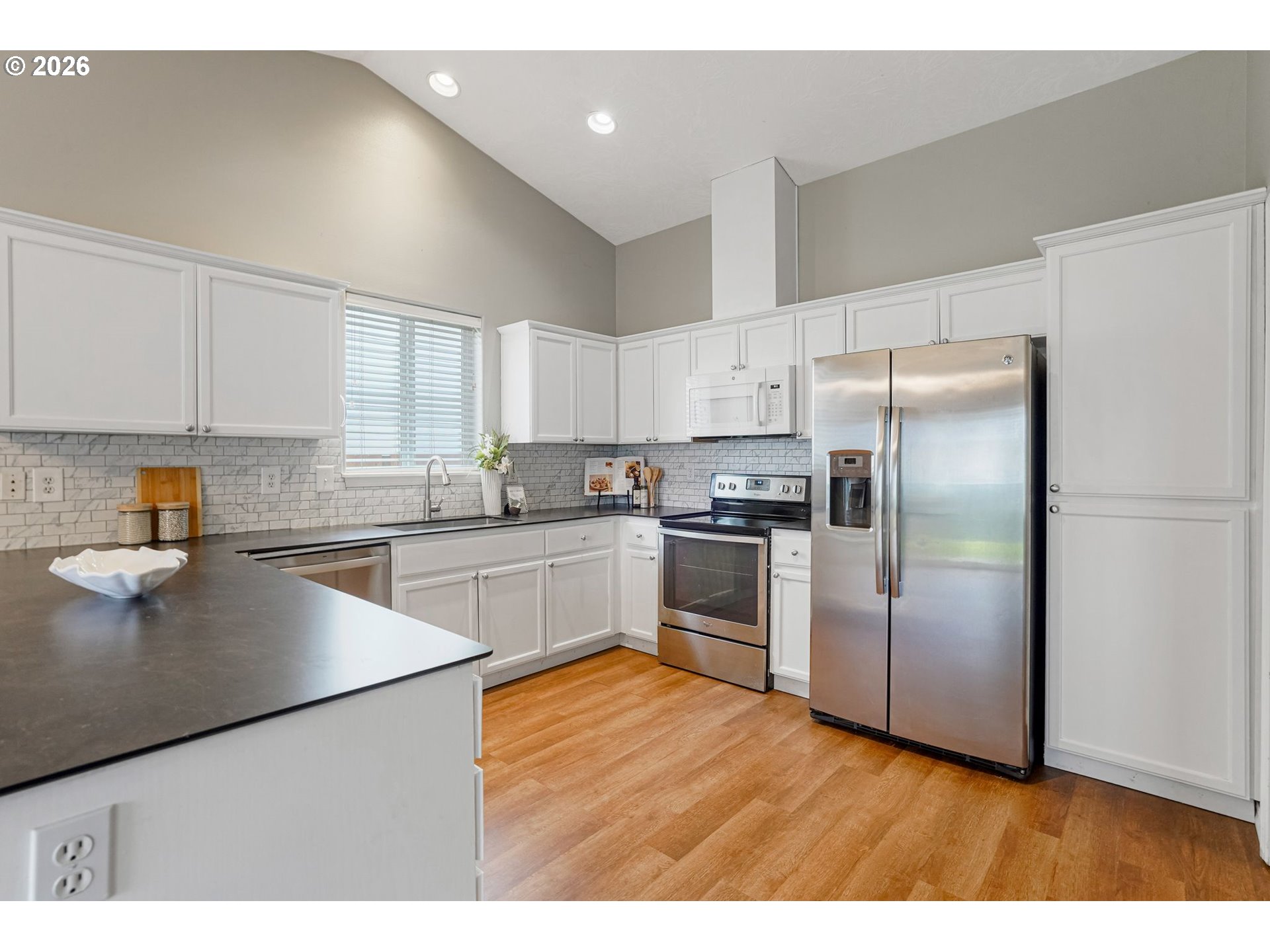 4791 Currant Lane Northeast Salem, OR 97305 - Photo 13 of 42 a kitchen with a refrigerator a sink dishwasher and a stove with wooden floor