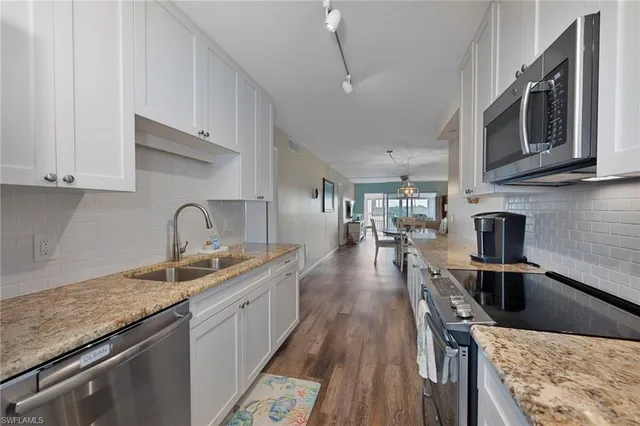 a kitchen with stainless steel appliances granite countertop a sink stove and microwave