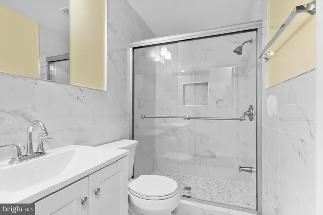 a bathroom with a sink mirror shower and toilet