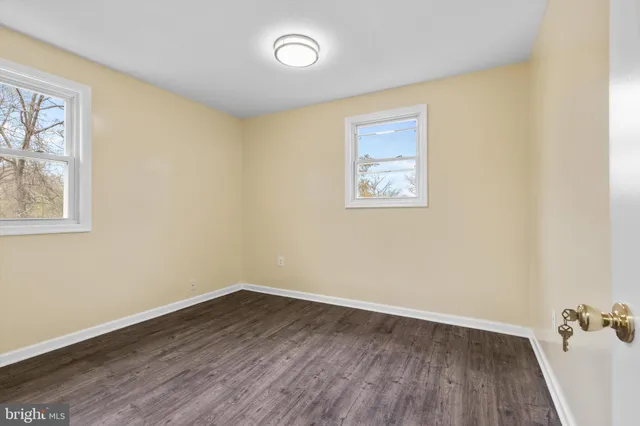 an empty room with a window and wooden floor