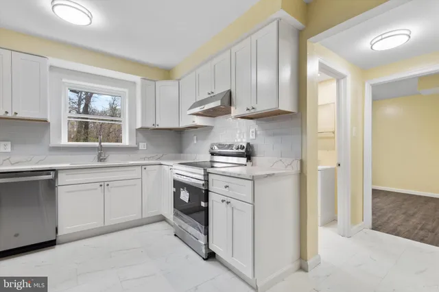a kitchen with cabinets appliances and a window