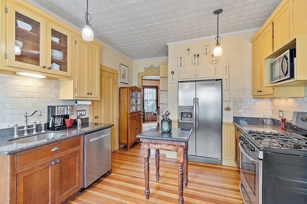 39 Maple Street Stoneham, MA 02180 - Photo 19 of 40 a kitchen with stainless steel appliances granite countertop a refrigerator a sink dishwasher a oven with white cabinets and wooden floor