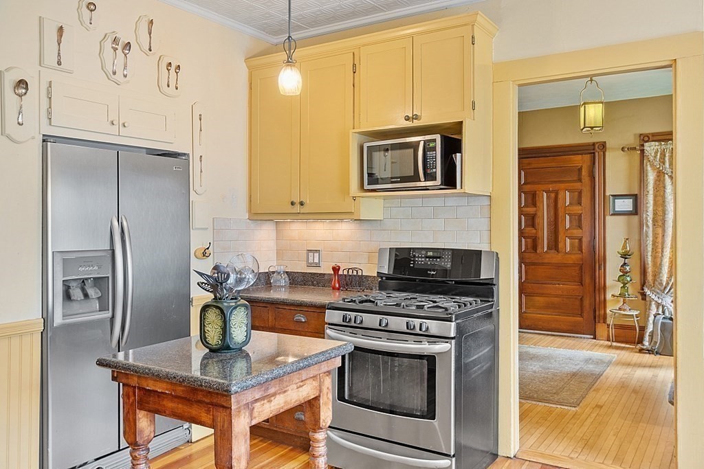 39 Maple Street Stoneham, MA 02180 - Photo 21 of 40 a kitchen with stainless steel appliances granite countertop a stove refrigerator and microwave