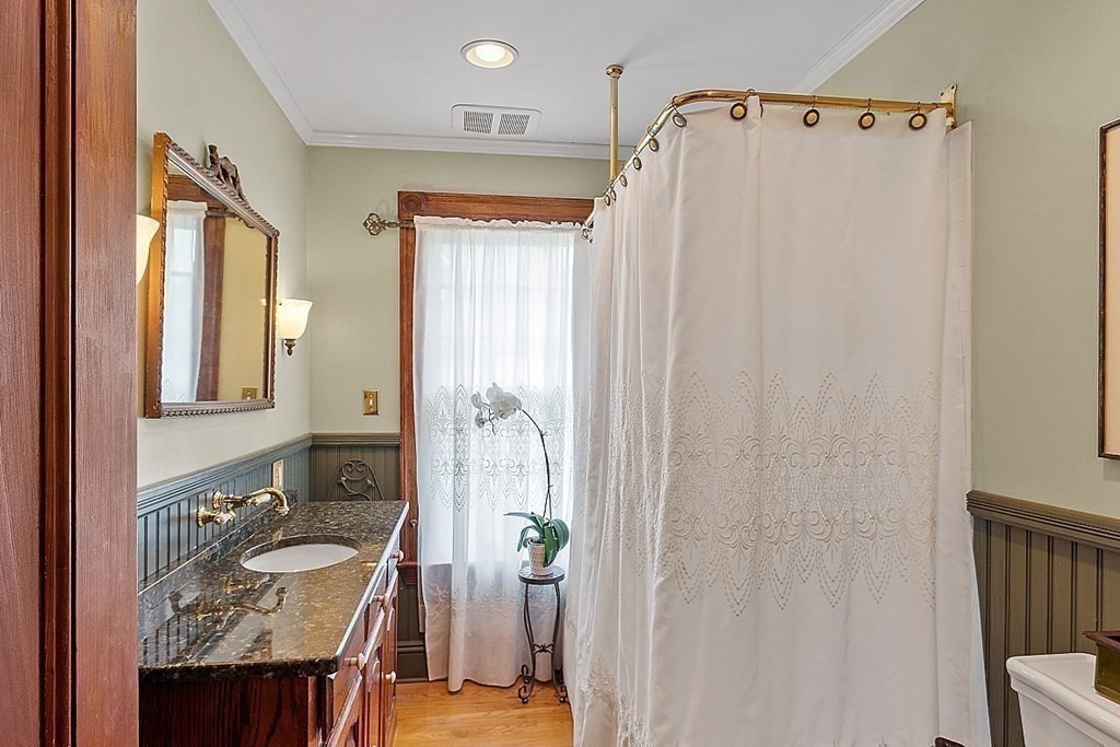 39 Maple Street Stoneham, MA 02180 - Photo 23 of 40 a bathroom with a sink a mirror and a shower curtain