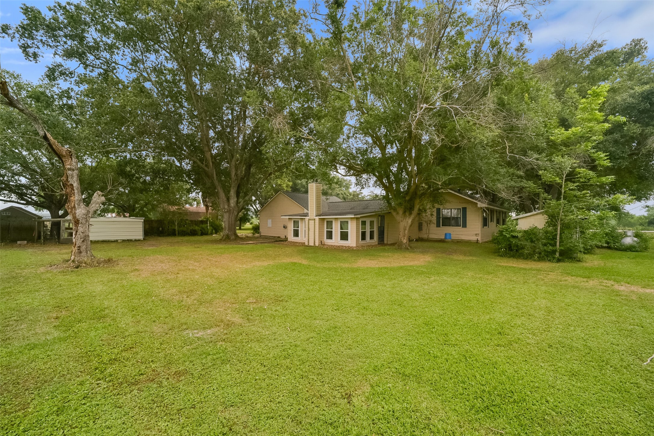 13710 Mueck Road Needville, TX 77461 - Photo 33 of 42 Charming single-story home nestled on a spacious lot with mature trees, offering a serene and shaded backyard.