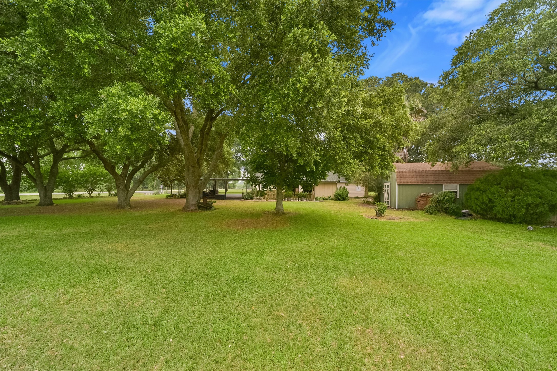13710 Mueck Road Needville, TX 77461 - Photo 37 of 42 This is a single-story home with a large, lush front yard dotted with mature shade trees, offering a serene and private setting.