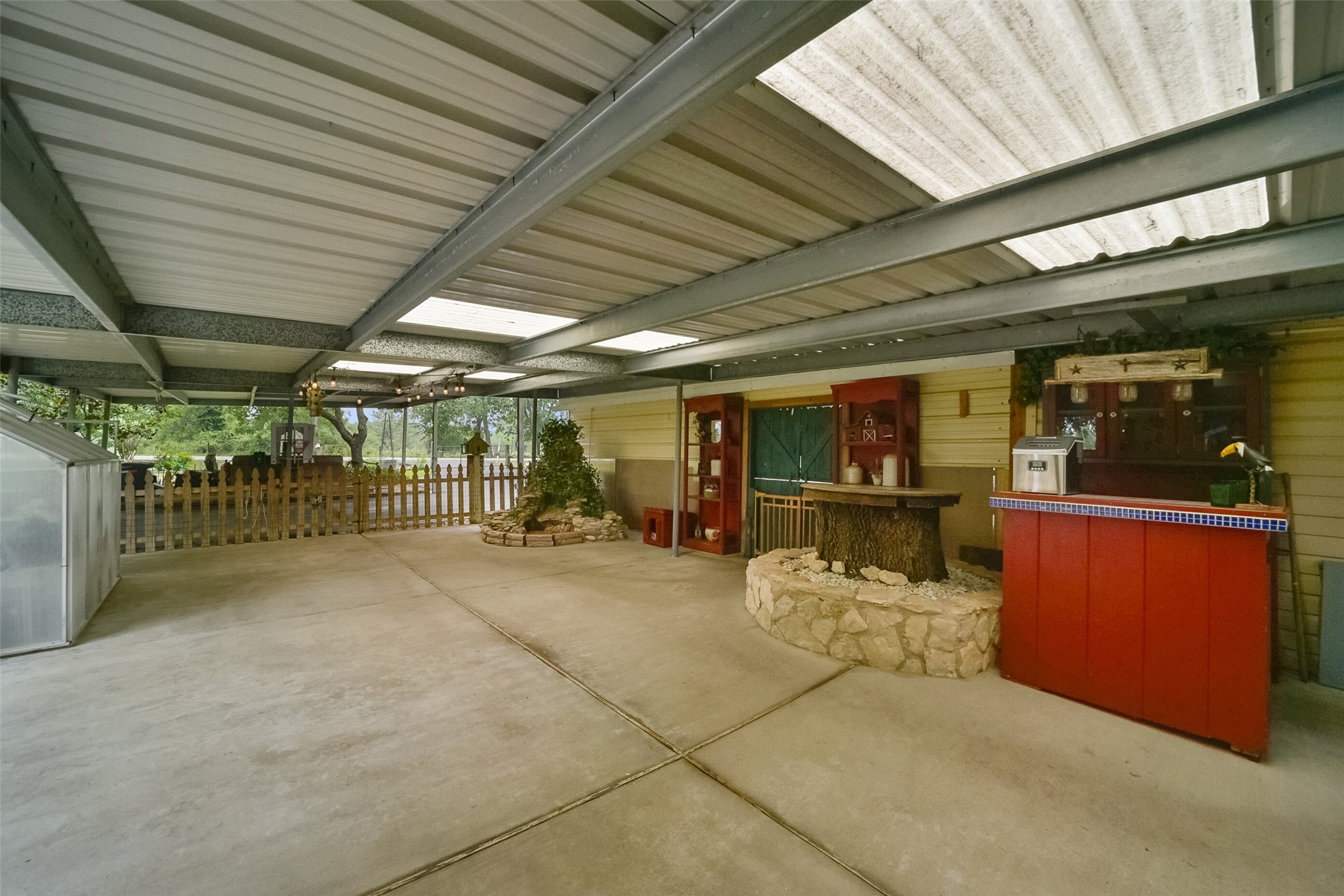 13710 Mueck Road Needville, TX 77461 - Photo 42 of 42 This is a spacious outdoor entertainment area featuring a covered patio with a built-in bar, ample space for seating, and a fenced perimeter for privacy.