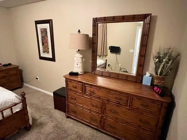 a bedroom with a bed and a mirror on dresser