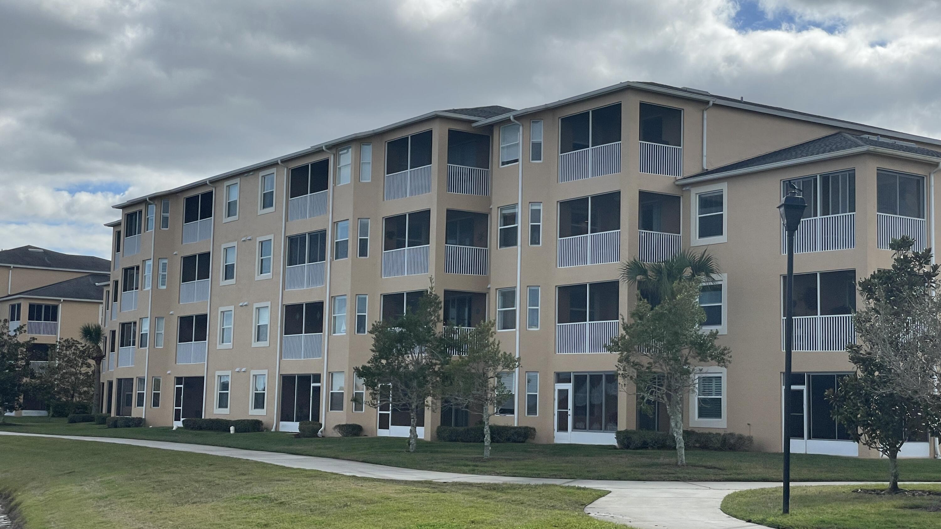 6828 Toland Drive, Unit 302 Melbourne, FL 32940 - Photo 24 of 45 a front view of a building with a yard