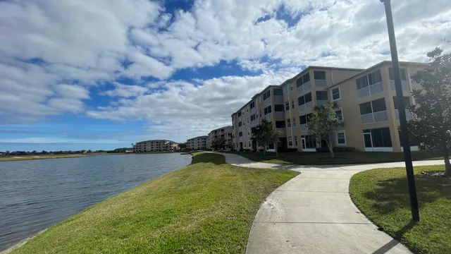 a view of a lake with a big yard and large trees