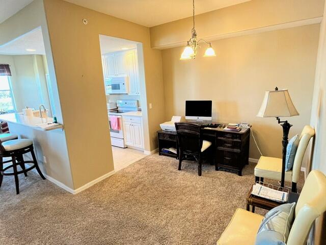 6828 Toland Drive, Unit 302 Melbourne, FL 32940 - Photo 5 of 45 a view of a workspace with furniture and a chandelier