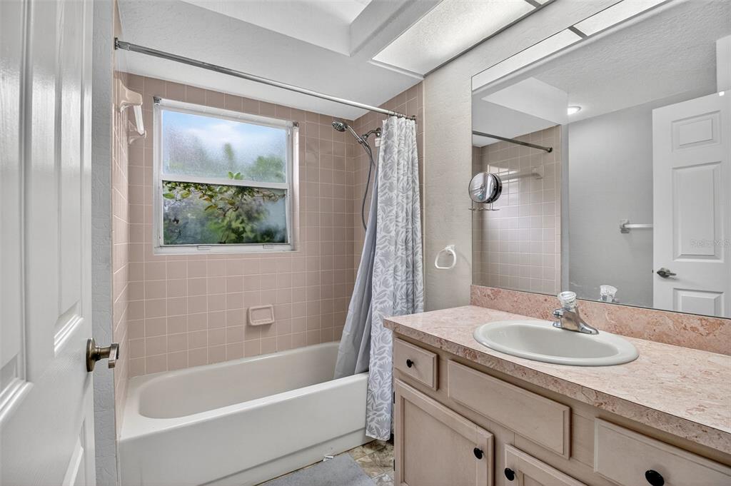 8841 Kipling Avenue Hudson, FL 34667 - Photo 30 of 41 a bathroom with a granite countertop sink a mirror a shower and a bathtub