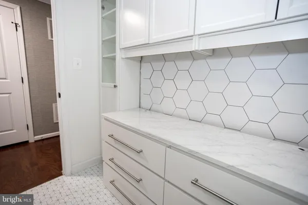 a view of entryway and kitchen with wooden floor